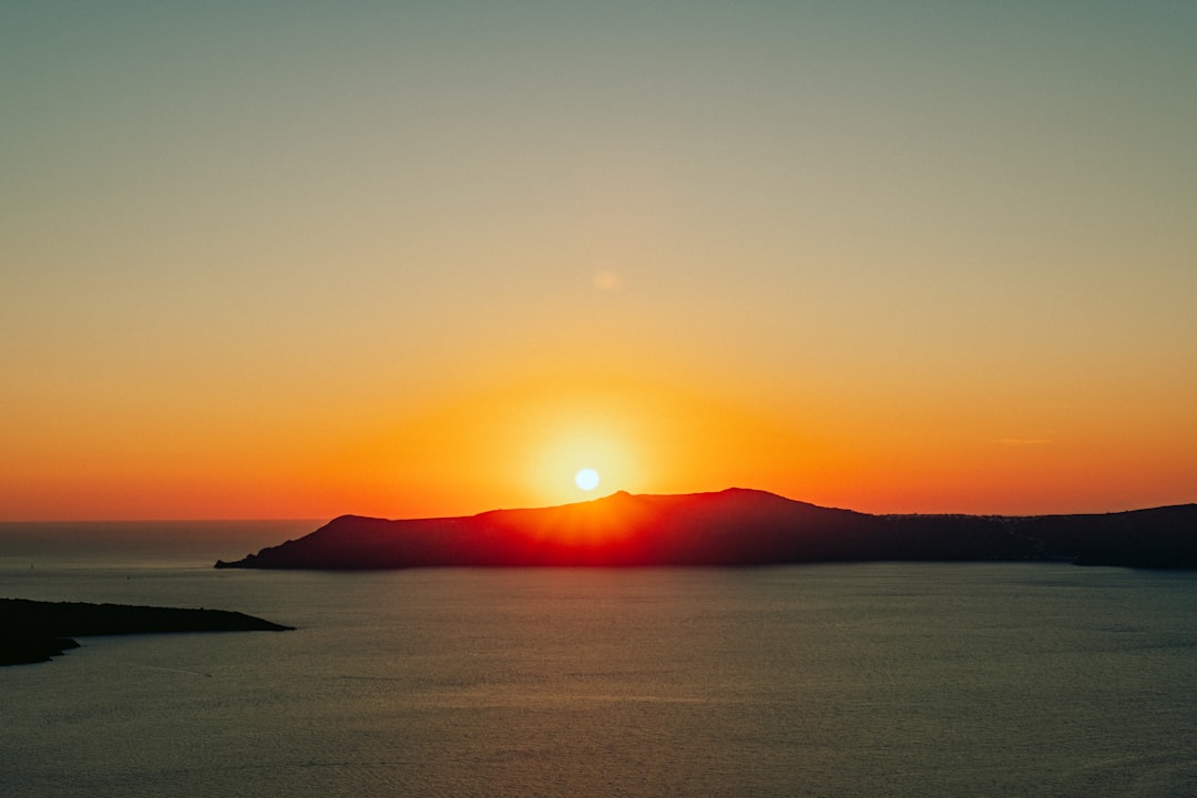 the-sun-is-setting-over-a-body-of-water-8tMbbtSyzeg.jpg